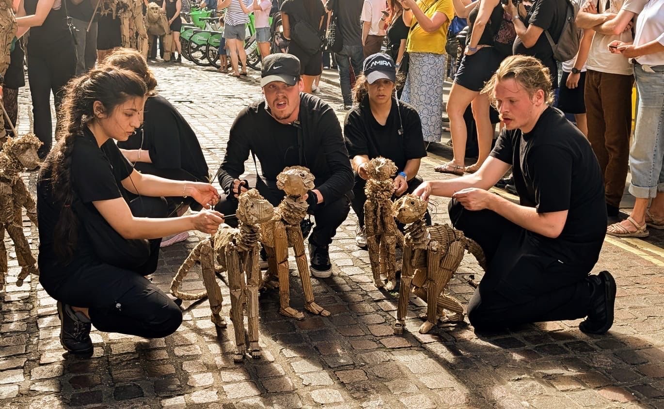 Puppeteers operating handmade animal puppets outdoors