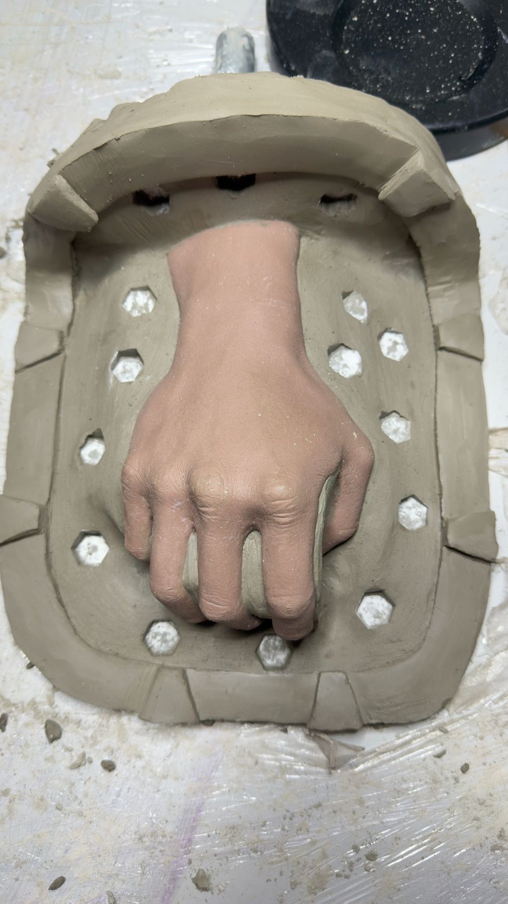 Clay mould around a hand cast with registration keys